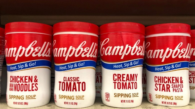 Several Campbell's soups on a shelf, including Creamy Tomato.