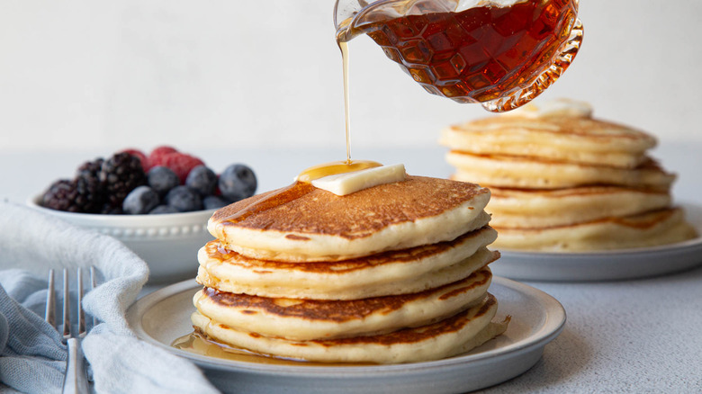 Syrup pouring over stack of pancakes