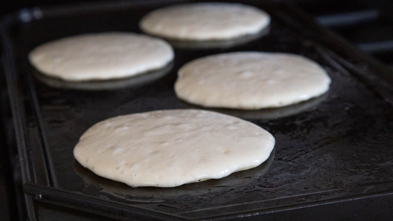 Raw pancakes on griddle