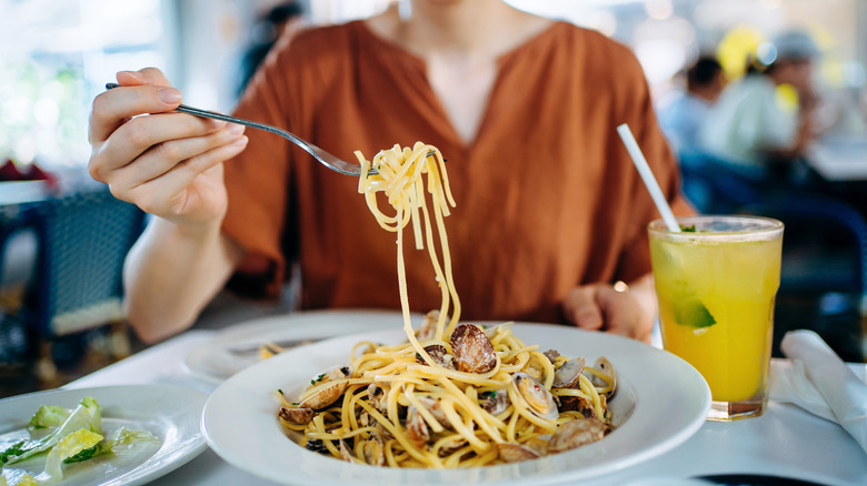 Person scooping up spaghetti at restaurant