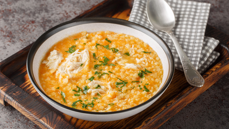 Colorful bowl of pastina in broth with chicken and vegetables