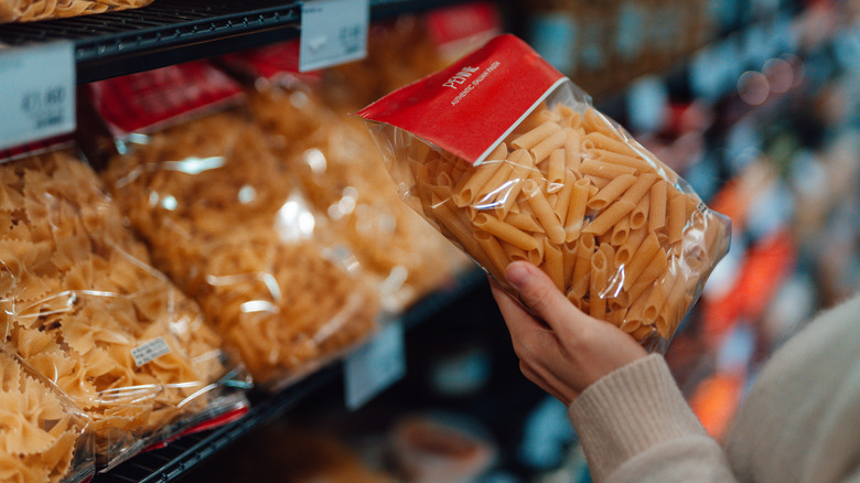 Person shopping for pasta at the grocery store