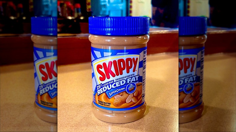 Jar of reduced fat Skippy peanut butter on a countertop