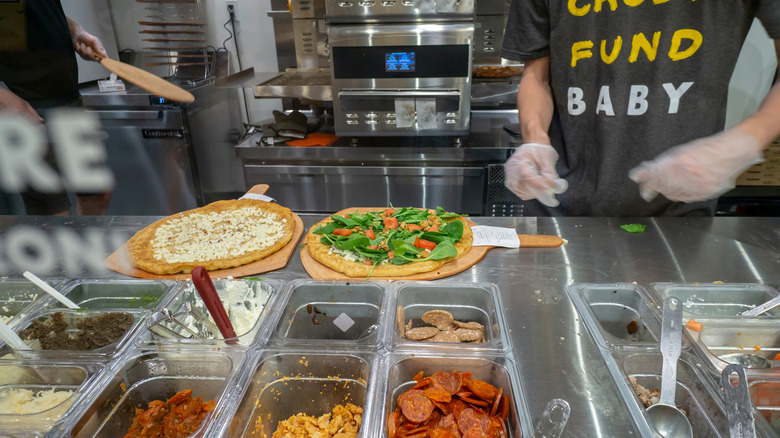 Workers making pizza at Oath Pizza