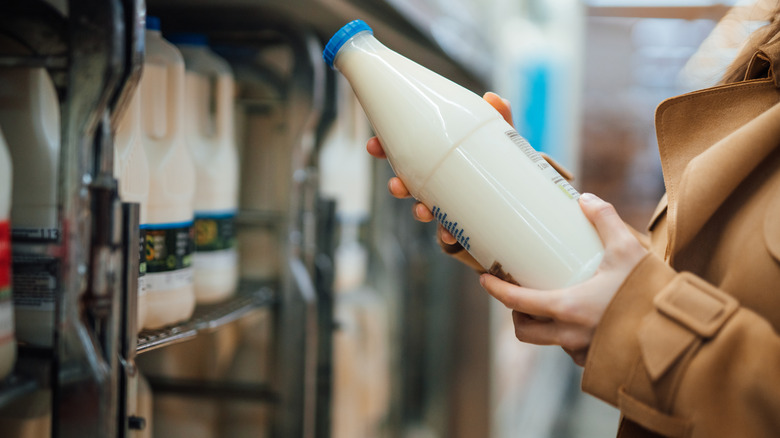 Person buying milk at the grocery store