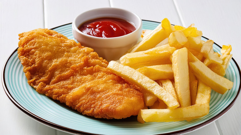 Fish and chips on a plate with ketchup