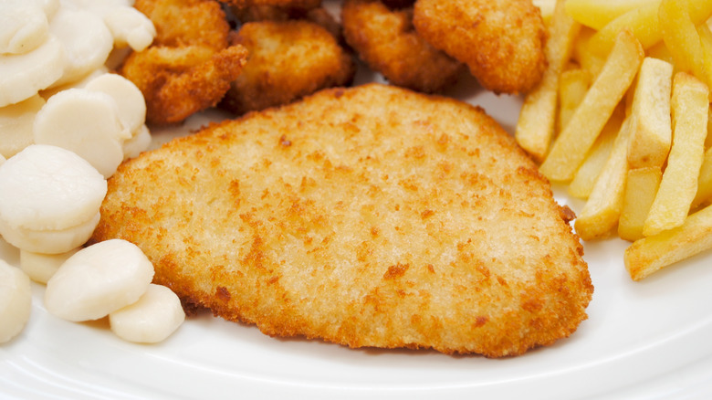 Breaded haddock on plate with other fried foods