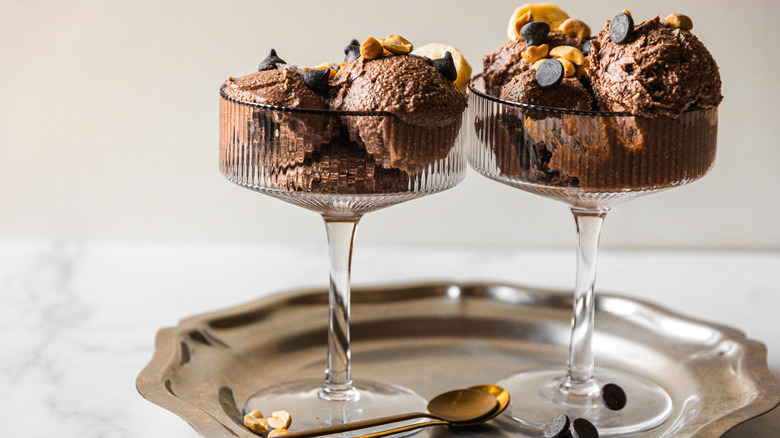 Two glasses of chocolate ice cream with chocolate chips and peanuts