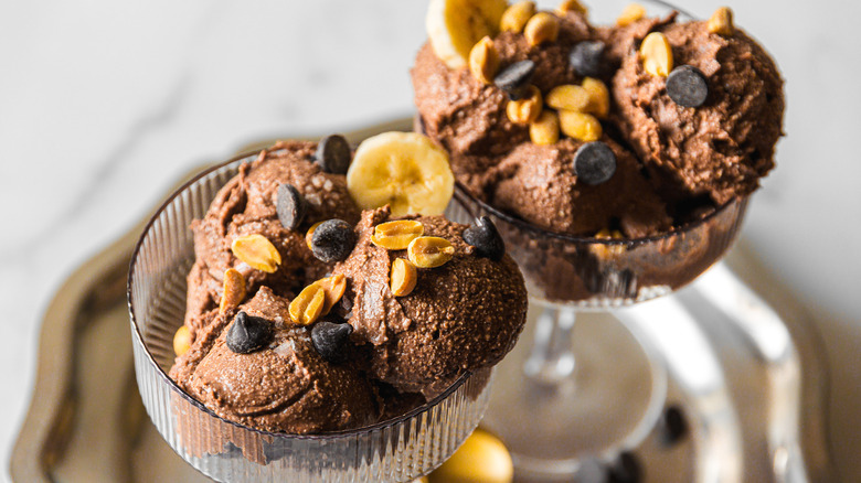 Two glasses of chocolate ice cream with chocolate chips and peanuts