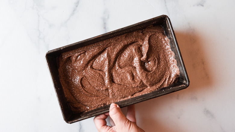 Hand holding pan of chocolate ice cream