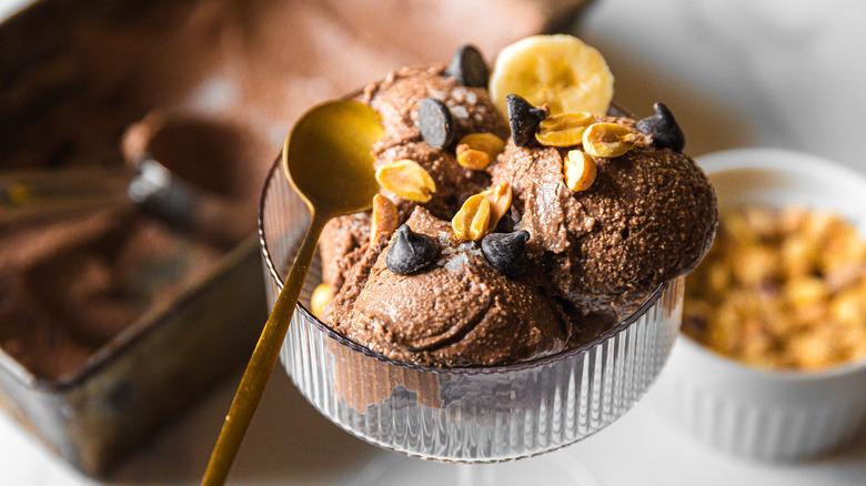 Chocolate ice cream with big container and peanuts in background