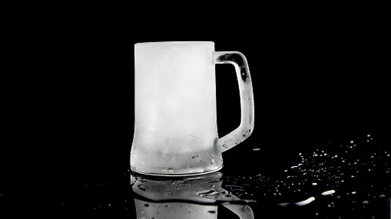 People holding glasses of beer while clinking them together