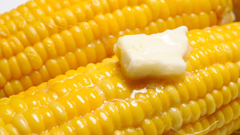 A close up of corn with melted butter on top