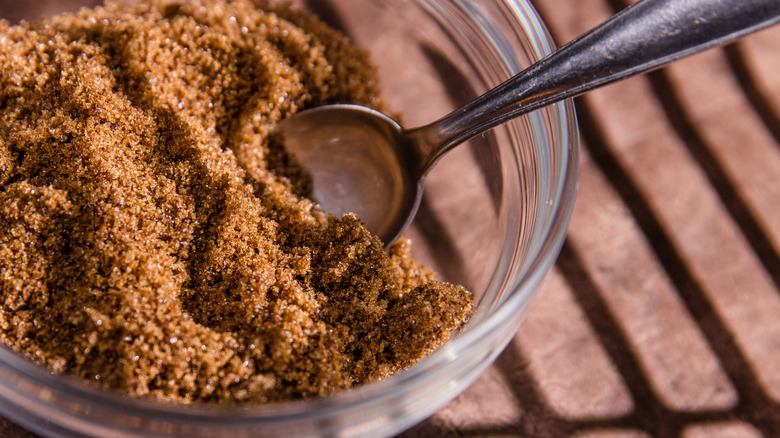 Glass bowl of brown sugar with a spoon in it