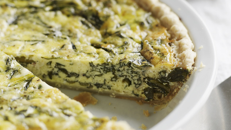 Spinach quiche with a missing slice