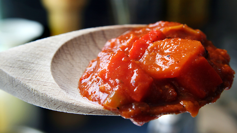 Close up shot of chunky salsa on a wooden spoon