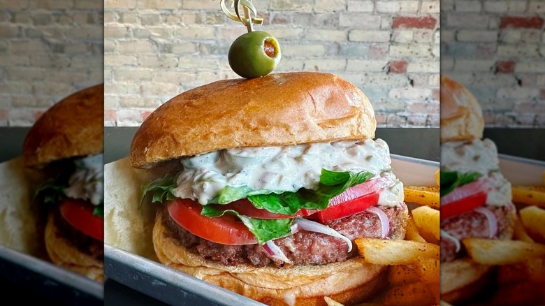 Olive burger topped with a green olive