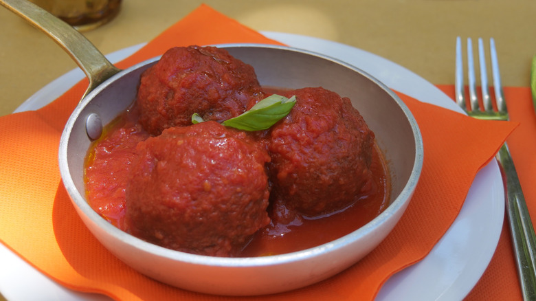 Pallotte cacio in tomato sauce in a pan on a plate