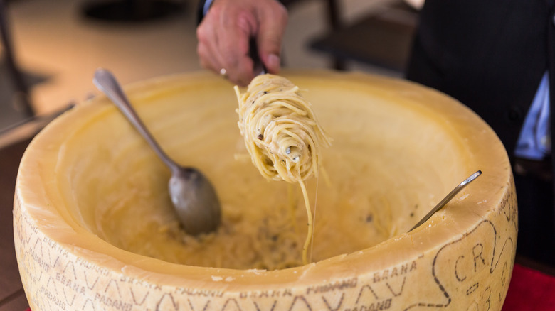 Chef making spaghetti in a Parmesan wheel