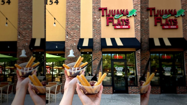 Hands hold churros in front of Tijuana Flats