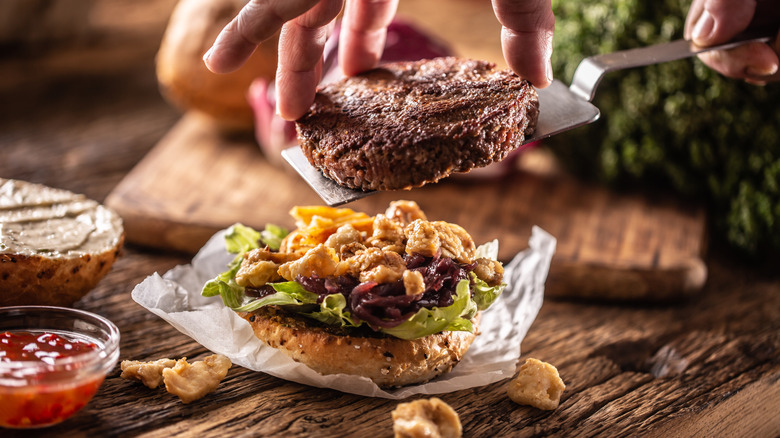 burger being placed on bottom bun