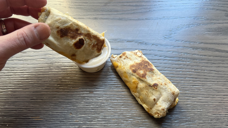 dipping one of Taco Bell's Cheesy Dipping Burritos