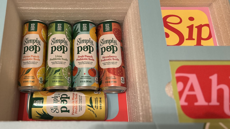 a colorful box holding Coca-Cola Simply Pop cans