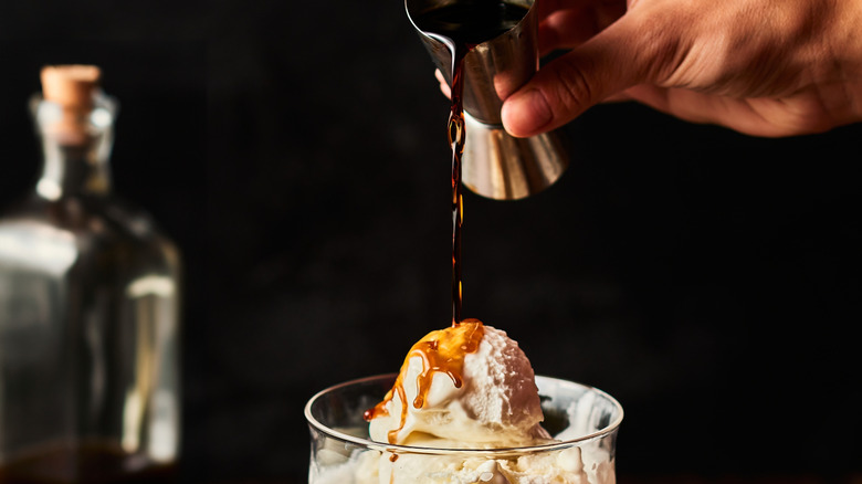 Coffee liquor poured over vanilla ice cream in a cocktail glass