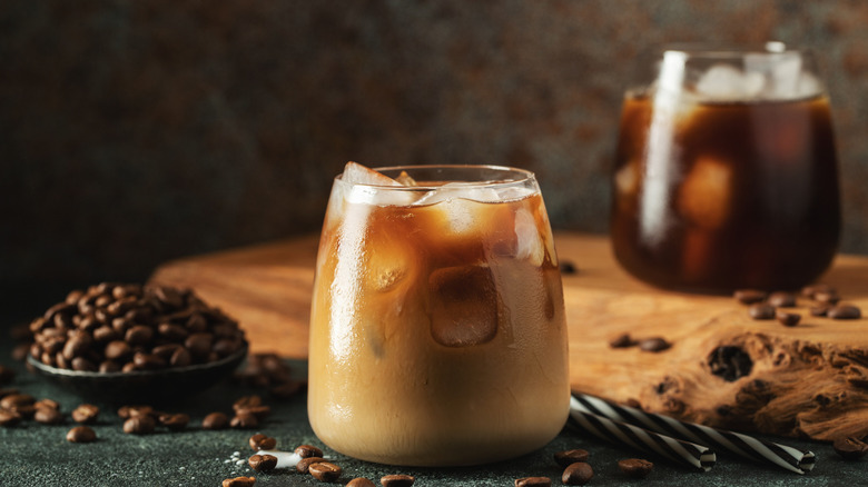 two glasses of coffee cocktails with bowl of coffee beans and straws