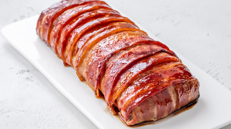 meatloaf wrapped in bacon on a rectangular white plate