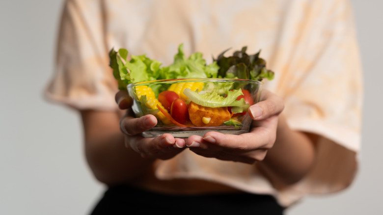 Person holding salad bowl