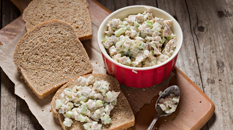 Bowl of chicken salad next to bread slices