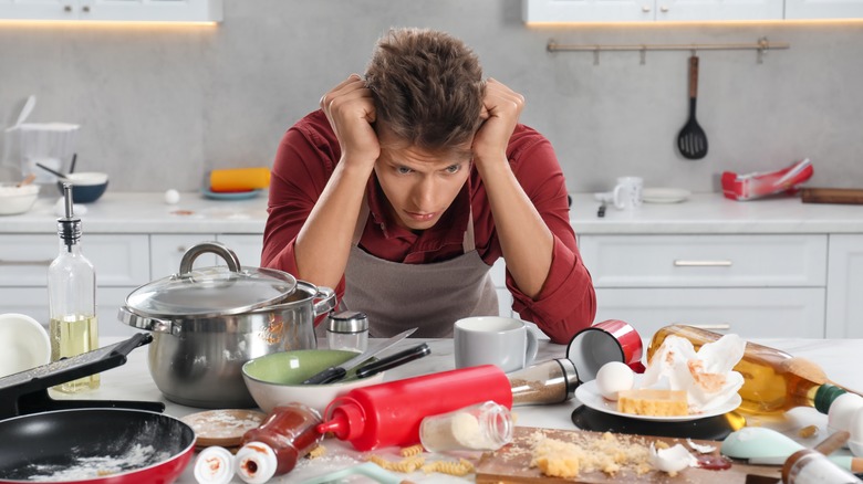 man upset in the kitchen with huge mess to clean