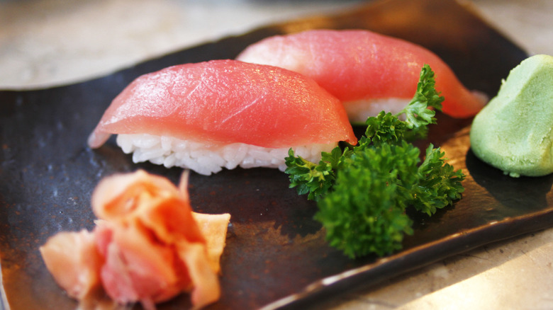 Tuna sushi on a plate with ginger and wasabi