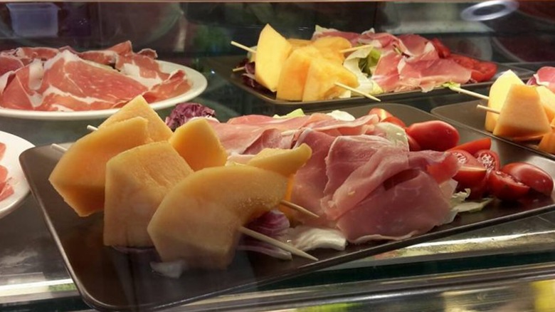 cured meats and fruits offered for sale at a Chef Express in Italy