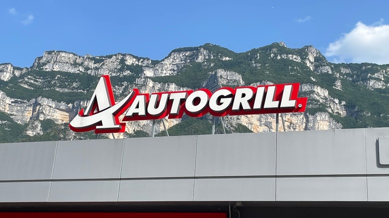 autogrill sign with mountains behind it