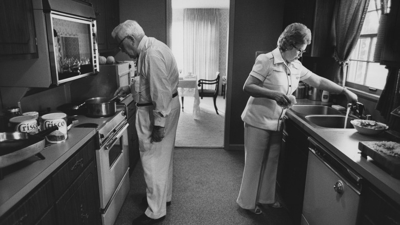 Sanders cooking with wife