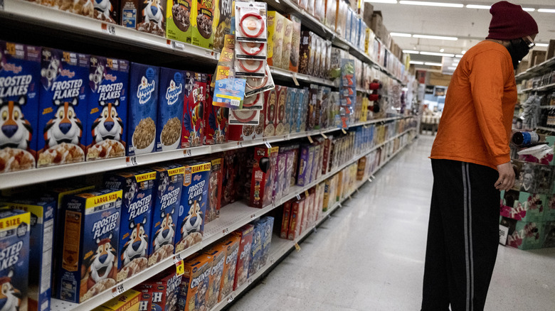 man with back to cereals on store shelf