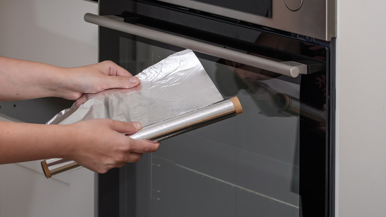 unrolling aluminum foil in the kitchen