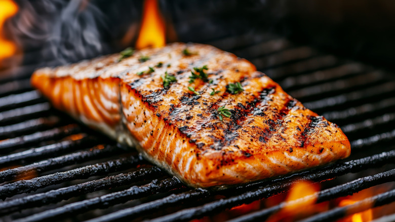 A piece of fish cooking on a grill skin-side down