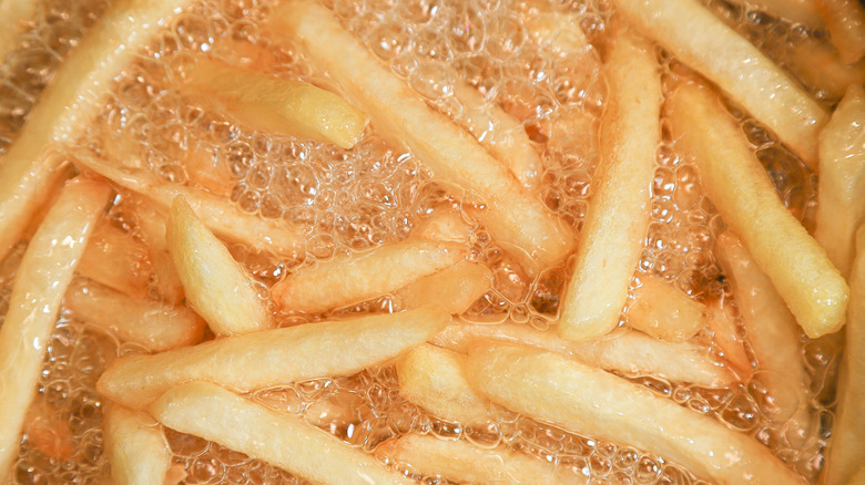 A batch of crispy fries cooking in hot oil