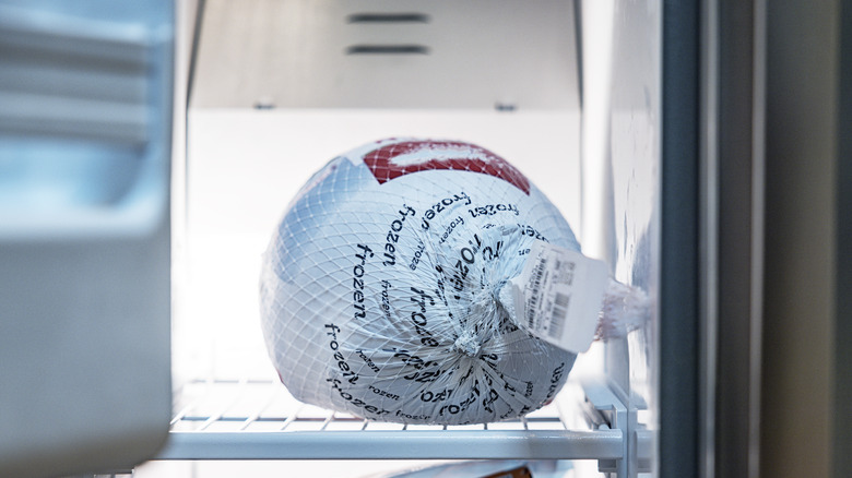 A frozen turkey in a freezer.