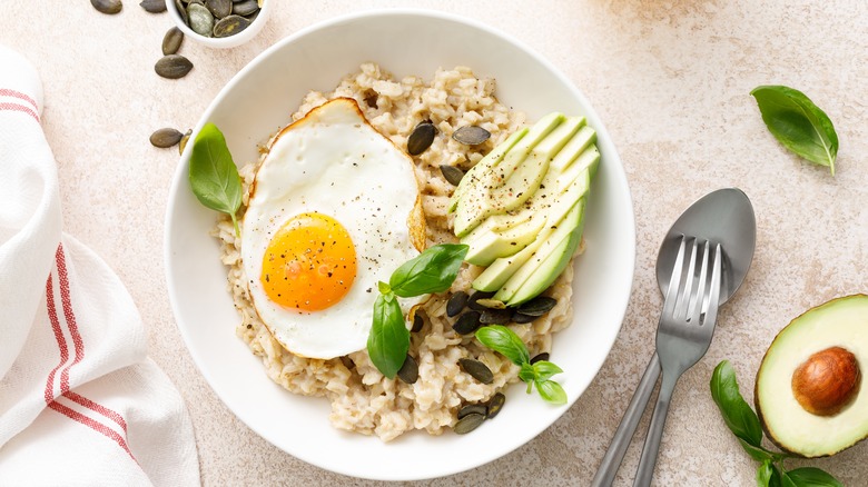 Savory oatmeal with sliced avocado and a fried egg