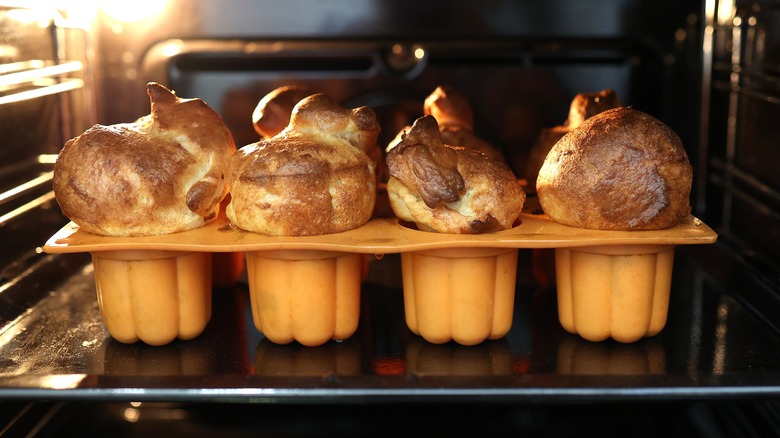 A tray of popovers cooking in the oven