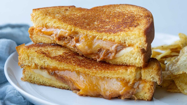 smoky pulled pork grilled cheese cut in half