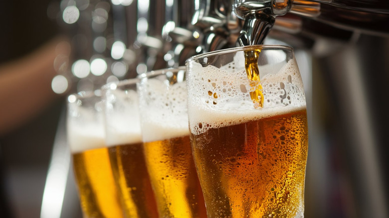 Four glasses being filled with beer