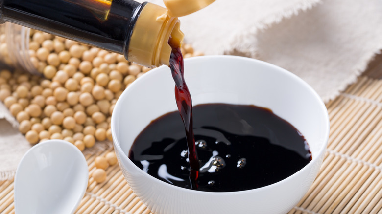 soy sauce in a bowl surrounded by soy beans