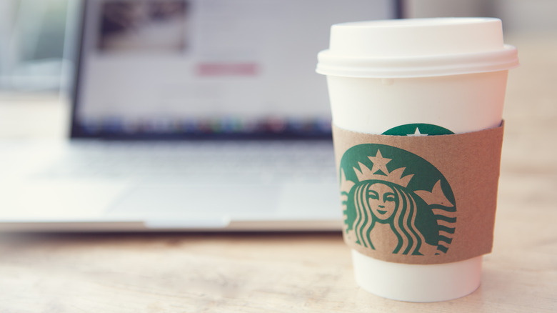 starbucks cup by laptop