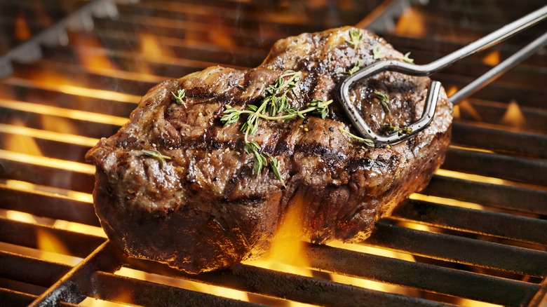 steak being turned on grill