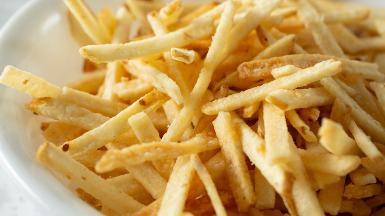 Shoestring fries are piled in a bowl